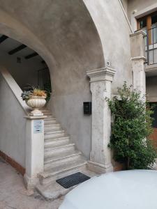 an entrance to a building with a vase with a plant at Monolocale in casa del 700 in Belvedere