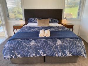 a bedroom with a bed with two slippers on it at Seacroft Beach House in Sugarloaf