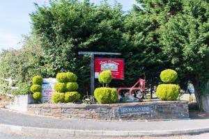 un cartel en un jardín con arbustos y árboles en Ty Bach en Aberystwyth