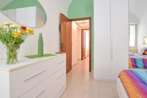 een slaapkamer met een vaas met bloemen op een dressoir bij Casa Titen in Ventimiglia