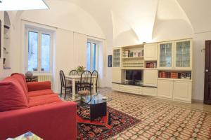 een woonkamer met een rode bank en een tafel bij Casa Titen in Ventimiglia