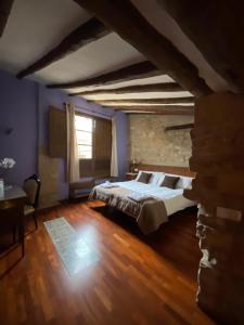 a bedroom with a large bed and a stone wall at Hotel del Sitjar in Calaceite