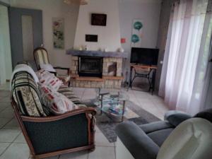 a living room with a couch and a fireplace at Maison LABORDE in Saint-Agnet