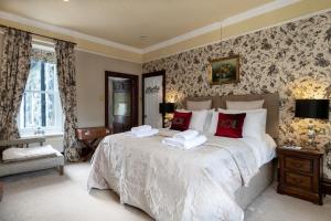 ein Schlafzimmer mit einem großen Bett mit roten Kissen in der Unterkunft Afon Rhaiadr Country House in Dolgellau