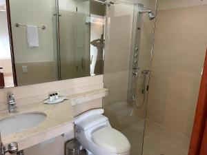 een badkamer met een douche, een toilet en een wastafel bij PlazaMar Pacifico Hotel in Buenaventura