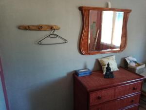 - une commode en bois avec un miroir sur un mur dans l'établissement Chambre chez l'habitant, à Pierrelatte