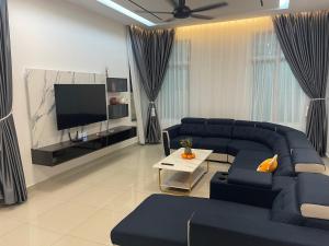 a living room with a blue couch and a tv at 家好月圆 Sweet Home in Kampong Seri Gading