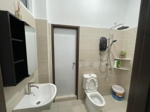 a bathroom with a toilet and a sink and a shower at 家好月圆 Sweet Home in Kampong Seri Gading