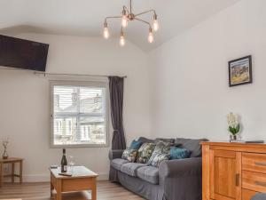 a living room with a couch and a window at Derwent Apartment in Glossop