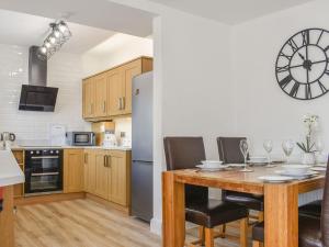 y cocina con mesa, sillas y nevera. en Derwent Apartment, en Glossop