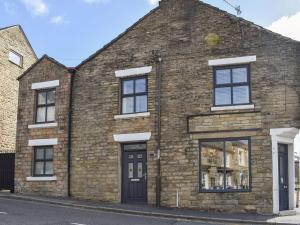 an old brick building with black doors and windows at Derwent Apartment in Glossop