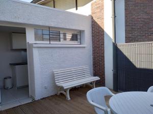 un banc en bois installé sur une terrasse à côté d'un bâtiment dans l'établissement La Bernaudine bis, à Annonay
