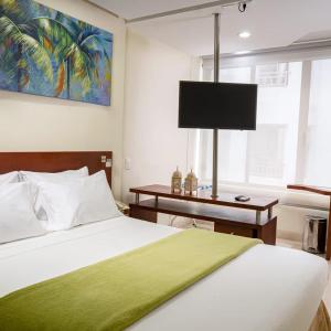 a bedroom with a bed with a television on the wall at PlazaMar Pacifico Hotel in Buenaventura