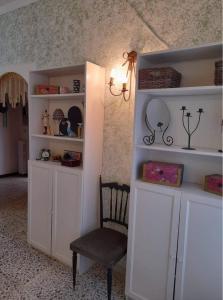 una habitación con estanterías blancas y una silla en Campanino68 en San Martino Valle Caudina