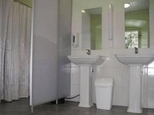 a bathroom with two sinks and a toilet and a mirror at Sagadi Manor Hostel in Sagadi