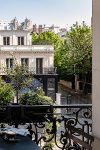 فندق غراند بيغال  في باريس: شرفة مع طاولة وكراسي ومبنى