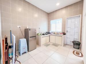 a kitchen with a refrigerator and a tile wall at Golden Sweet Home @ Golden Hills (Night Market, 夜市) in Tanah Rata