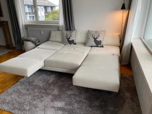 a white couch in a living room with a window at Ludwigslust - Ferienappartement mit Bergblick in Schwangau