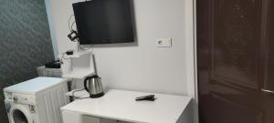 TV en la parte superior de una pared blanca con microondas en Midtown Hotel Apartments 404 ( 2+1) en Estambul