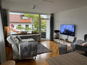a living room with a large window and a tv at Ludwigslust - Ferienappartement mit Bergblick in Schwangau