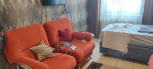 uma sala de estar com uma cadeira laranja e uma cama em Midtown Hotel Apartments 404 ( 2+1) em Istambul