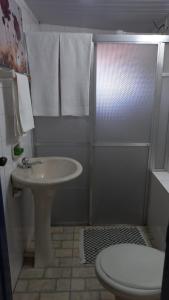 a bathroom with a sink and a shower with a toilet at Suíte no Centro Histórico in Ouro Preto