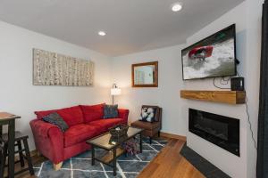 ein Wohnzimmer mit einem roten Sofa und einem Kamin in der Unterkunft Studio Purgatory Townhome 104 in Durango Mountain Resort