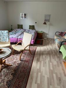 a living room with beds and a chair and a rug at Bramming city bed & breakfast , ingen morgenmad in Bramming