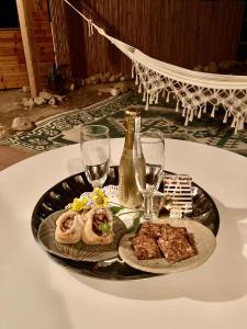 ‘EzuzにあるTobiana Desert Lodging Negevのテーブルの上に食べ物とワイングラスを入れたトレイ