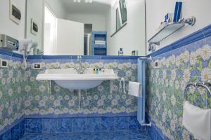 a bathroom with a white sink and blue tiles at Relais Maresca Luxury Small Hotel & Terrace Restaurant in Capri