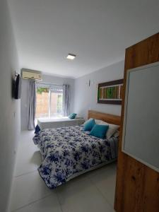 sypialnia z łóżkiem z niebieskimi poduszkami w obiekcie Paúba Beach Hotel w mieście Pauba