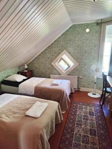 a bedroom with two beds and a window at Hotel & Cafe Lanterna in Nauvo