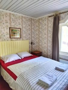 a bedroom with a bed with two towels on it at Hotel & Cafe Lanterna in Nauvo