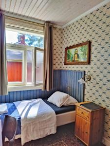 a small bedroom with a bed and a window at Hotel & Cafe Lanterna in Nauvo