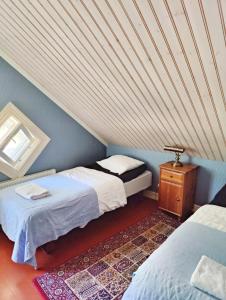a attic room with two beds and a table at Hotel & Cafe Lanterna in Nauvo