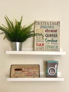 a shelf with a plant and a coffee break sign at La Fonda del Arco in Guadix