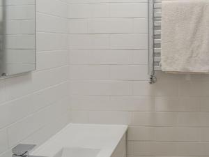 a white bathroom with a sink and a mirror at The Seaside Suite in Helensburgh