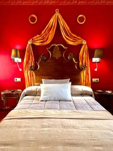 トレドにあるアルムニア デ サン ミゲルの赤い壁のベッドルーム1室(大型ベッド1台付)