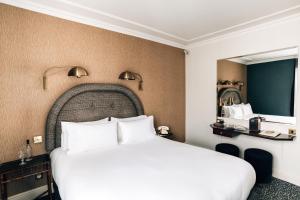 1 dormitorio con 1 cama grande y espejo grande en Grand Pigalle Hotel en París