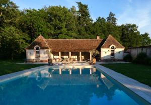 une grande piscine en face d'une maison dans l'établissement Chateau des Grotteaux Près Chambord, à Chambord