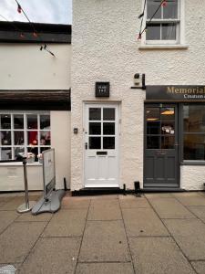 einen Laden mit Tür und Schild davor in der Unterkunft Historic Grade 2 listed, Town centre, St.Neots Cambridgeshire in Hail Weston