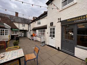 a patio with chairs and a table in front of a restaurant at Historic Grade 2 listed, Town centre, St.Neots Cambridgeshire in Hail Weston