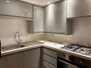 a kitchen with a sink and a stove top oven at Historic Grade 2 listed, Town centre, St.Neots Cambridgeshire in Hail Weston