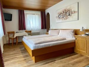 a bedroom with a bed and a table in a room at Haus Gröblacher in Mayrhofen