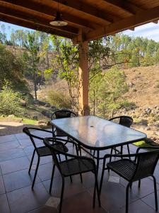 a table and chairs on a patio with a view at Serranias Del Tabaquillo in San Miguel de los Rios