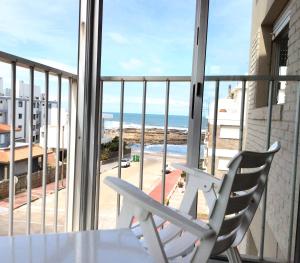 a white chair sitting on a balcony with a view of the ocean at ap frente mar Península Punta Del Este in Punta del Este
