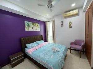Santubong Suites Sejinjang في كوتشينغ: غرفة نوم أرجوانية مع سرير وجدار أرجواني
