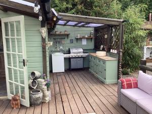 a kitchen on a deck with an outdoor kitchen at Bosvean Cottage in Bude