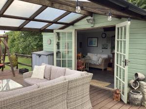a patio with a couch on a deck at Bosvean Cottage in Bude