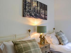 1 dormitorio con 1 cama y 1 mesa con lámpara en Milnfield Cottage en Annan